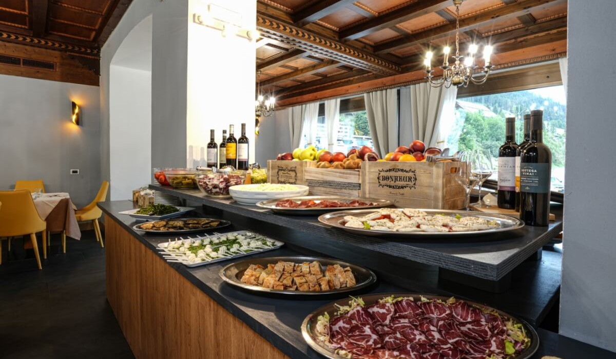 Hotel Monzoni - Ricco buffet tipico della tradizione locale con ampia scelta di antipasti, frutti e vino.