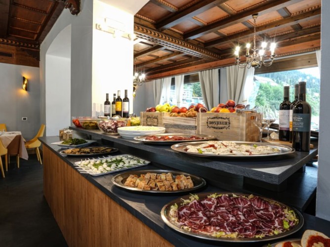 Hotel Monzoni - Ricco buffet tipico della tradizione locale con ampia scelta di antipasti, frutti e vino.