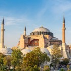 La maestosa Chiesa di Santa Sofia, con la sua imponente cupola e i minareti, domina la storica Piazza Sultanahmet a Istanbul, simbolo di arte bizantina e storia millenaria.