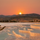 Le piscine e terrazze di travertino a Pamukkale al tramonto si tingono di colori caldi, creando un paesaggio fiabesco tra acque cristalline e formazioni naturali uniche.
