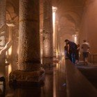 Una scultura raffigurante una mano emerge in una colonna della Basilica Cisterna di Istanbul, tra riflessi d’acqua, leggende antiche e atmosfera sommersa.