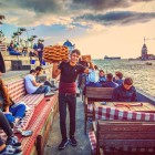 Sul lungomare di Üsküdar, un caffè offre viste sulla Torre di Leandro mentre un venditore di simit propone il tipico bagel turco agli avventori.