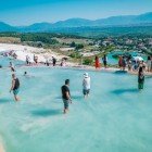 Alcuni turisti e visitatori che si immergono nelle acque termali delle vasche di Pamukkale