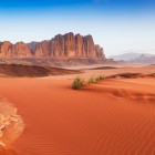 Wadi Rum, il famoso deserto rosso della Giordania, incanta con paesaggi mozzafiato e la storia di Lawrence d’Arabia.