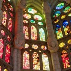 All’interno della Sagrada Família, le vetrate accendono la pietra di rosso, verde e blu, trasformando le colonne ispirate agli alberi nella foresta di luce sacra ideata da Gaudí.