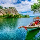 Le tradizionali imbarcazioni in legno del fiume Dalyan navigano lentamente attraverso la lussureggiante vegetazione, offrendo panorami mozzafiato delle tombe scavate nella roccia e splendidi scorci sulla fauna locale.