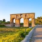 L’antico ingresso di Patara, con l’imponente arco monumentale romano, accoglie i visitatori tra rovine storiche e paesaggi mediterranei, testimoni della grandezza della Licia antica.