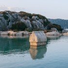 Il sarcofago di Simena, oggi Kaleköy, affiora dalle acque cristalline del Mediterraneo, tra colline scoscese. Un prezioso tesoro archeologico della Licia.