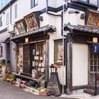 Ristorante tradizionale giapponese in legno nel tranquillo e nostalgico quartiere di Yanaka Ginza, decorato con le piastrelle religiose Ema, simbolo di speranza e preghiera.