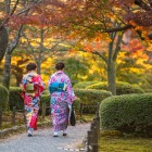 Ragazze con vestiti tradizionali a passeggio nei viali del parco Kenroku-en a Kanazawa nella prefettura di Ishikawa considerato uno dei tre giardini più belli del Giappone.