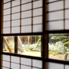 Le pareti in carta di riso di un ryokan a Takayama creano un'atmosfera autentica, mentre gli ospiti gustano piatti tradizionali locali preparati con ingredienti freschi e di alta qualità.