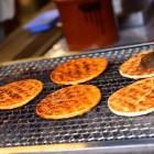 Deliziosi cracker di riso giapponesi vengono grigliati sul momento tra i profumi e i colori del vivace mercato mattutino di Takayama, uno dei luoghi più autentici del Giappone tradizionale.