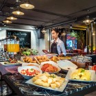 Ricca colazione a buffet con piatti asiatici e internazionali, frutta fresca, dolci, salumi, uova su ordinazione e ottimo caffè: un risveglio perfetto nel cuore di Bangkok.
