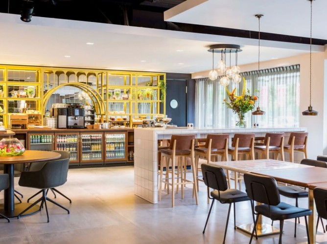Adagio Amsterdam City South - La sala colazione, con design urbano ispirato ai laboratori classici, crea un’atmosfera dinamica e rilassante. L’uso di materiali naturali e luce naturale minimizza l’impatto ambientale.
