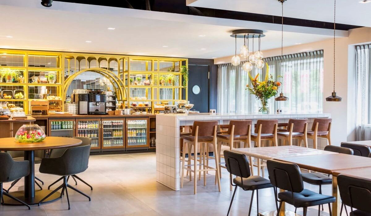 Adagio Amsterdam City South - La sala colazione, con design urbano ispirato ai laboratori classici, crea un’atmosfera dinamica e rilassante. L’uso di materiali naturali e luce naturale minimizza l’impatto ambientale.
