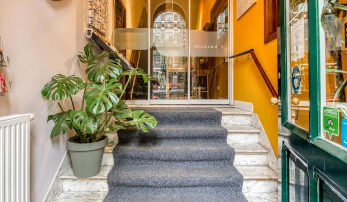Hotel Alexander - L’ingresso dell’Hotel Alexander è sobrio ed elegante, con una facciata tipica olandese e una porta accogliente che si apre su una reception calda e dal tocco familiare.
