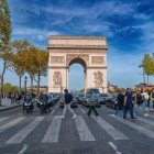 L’Arco di Trionfo si erge maestoso sui Champs-Élysées, incorniciato da alberi e palazzi eleganti che ne esaltano la prospettiva e la forza simbolica nel cuore di Parigi.