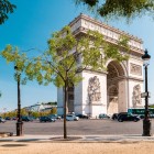 L’Arco di Trionfo di Parigi, imponente e neoclassico, è ornato da bassorilievi, sculture e iscrizioni che celebrano le glorie francesi. Alla base arde la Fiamma del Milite Ignoto.