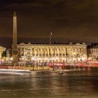 Di notte Place de la Concorde si illumina di luci dorate che riflettono sull’asfalto bagnato, mentre l’obelisco svetta al centro, imponente e silenzioso custode della piazza.