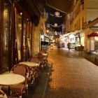 Rue Mouffetard di notte, una delle più antiche stradine parigine acciottolate a tarda notte con un mercato della frutta e una caffetteria ancora aperti.