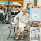 Un caricaturista di strada a Montmartre ritrae turisti con tratti rapidi e ironici. Tra cavalletti e colori, il suo talento cattura l’anima del quartiere più bohémien di Parigi.