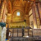 La tomba di Mevlana Rumi, custodita sotto la suggestiva Cupola Verde, è decorata con raffinati tessuti e antiche iscrizioni calligrafiche, un luogo di grande spiritualità e arte selgiuchide.