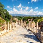 Antica via di Efeso tra colonne e statue, porta alla Biblioteca di Celso, simbolo di sapere e cuore culturale del mondo romano.