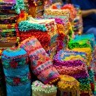 Vendita di tappeti tradizionali al Gran Bazar di Istanbul, con motivi ottomani intricati e tessuti artigianali che raccontano secoli di storia.