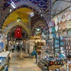 Interni del Gran Bazar di Istanbul, con strette vie affollate e negozi tradizionali che vendono spezie, tessuti e artigianato ottomano.