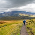 Turisti in cammino lungo il sentiero della laguna Limpiopungo, nel Parco Nazionale del Cotopaxi vicino Quito, tra paesaggi andini e viste sul vulcano innevato.