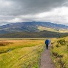 Turisti in cammino lungo il sentiero della laguna Limpiopungo, nel Parco Nazionale del Cotopaxi vicino Quito, tra paesaggi andini e viste sul vulcano innevato.