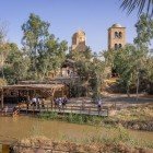 La sponda del fiume Giordano a Betania Al-Maghtas segna il luogo sacro del battesimo di Gesù, circondato da rovine antiche e paesaggi di grande spiritualità.