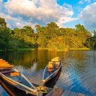 Canoe tradizionali in legno al tramonto sul fiume Napo, nella provincia di Cotopaxi, Ecuador, immerse nella magia della foresta amazzonica.