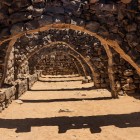 Le robuste volte di Qasr Azraq, realizzate in pietra basaltica, mostrano l’ingegneria difensiva romana e omayyade nel cuore del deserto.