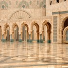 Gli esterni della Moschea di Hassan II incantano con eleganti archi e fontane che riflettono l’arte islamica, creando un’atmosfera di pace e grandiosità sul mare.