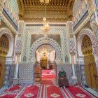 "La tomba di Moulay Idriss a Fès custodisce interni riccamente decorati con mosaici, stucchi e calligrafia islamica, simbolo di fede e arte marocchina.