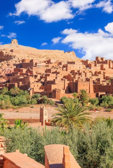 Aït Ben Haddou è un antico ksar in terra rossa vicino a Ouarzazate, patrimonio dell’UNESCO, noto per le sue torri merlate e il fascino dei villaggi berberi tradizionali.