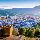 Chefchaouen vista dall’alto mostra un mosaico di case turchesi incastonate tra le montagne, un borgo unico che incanta con i suoi colori e l’atmosfera magica del Marocco.