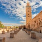 Minareto in pietra rosa della Koutoubia svetta tra gli aranci di Marrakech, esempio perfetto di architettura almohade del XII secolo.