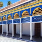 Sotto il porticato del Bahia, archi scolpiti e dipinti a mano incorniciano mosaici zellige geometrici, in un tripudio di blu cobalto, verde e ocra.