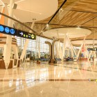 Gli interni dell’aeroporto di Marrakech-Menara combinano design moderno e dettagli marocchini, con ampi spazi luminosi e accesso ai gate attraverso vetrate panoramiche.