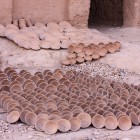 Nella fabbrica di ceramiche di Tamgroute, all’esterno si vedono piatti e vasi ancora non colorati, disposti al sole in attesa della smaltatura tradizionale verde.