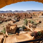 La vista dall’alto di Nkob rivela un intreccio di kasbah in terra rossa tra palmeti e colline aride, con lo Jbel Saghro che domina l’orizzonte.