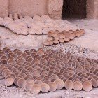 Nella fabbrica di ceramiche di Tamgroute, all’esterno si vedono piatti e vasi ancora non colorati, disposti al sole in attesa della smaltatura tradizionale verde.