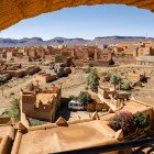 La vista dall’alto di Nkob rivela un intreccio di kasbah in terra rossa tra palmeti e colline aride, con lo Jbel Saghro che domina l’orizzonte.