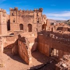 Gli esterni della Kasbah di Telouet dominano l’Alto Atlante con mura in terra cruda, torri imponenti e viste spettacolari lungo le antiche rotte carovaniere.