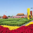 Giardini fioriti di Piazza Tian’anmen, armonia di colori e simmetrie che incorniciano l’imponenza storica del cuore monumentale di Pechino.