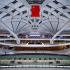 Interni dell’aeroporto di Pechino spaziosi e moderni, con aree lounge, negozi, ristoranti e servizi efficienti per un’esperienza di viaggio confortevole.