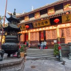 Esterno tradizionale del Tempio del Buddha di Giada a Shanghai, con architettura classica, decorazioni in legno e atmosfera spirituale autentica.