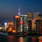 Vista notturna di Shanghai con grattacieli illuminati, il Bund e le luci della città che riflettono la modernità e la storia della metropoli cinese.